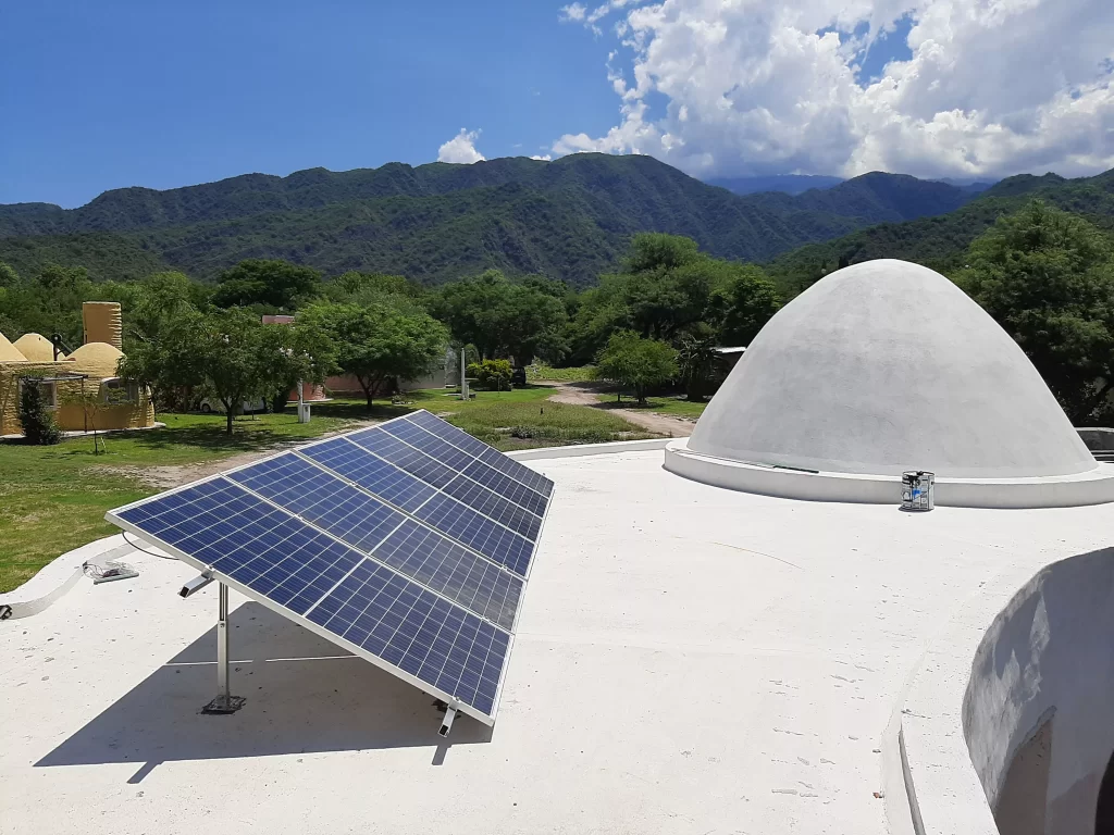 Paneles solares apra generar energía fotovoltaica colocados sobre el techado de una residencia en la ciudad