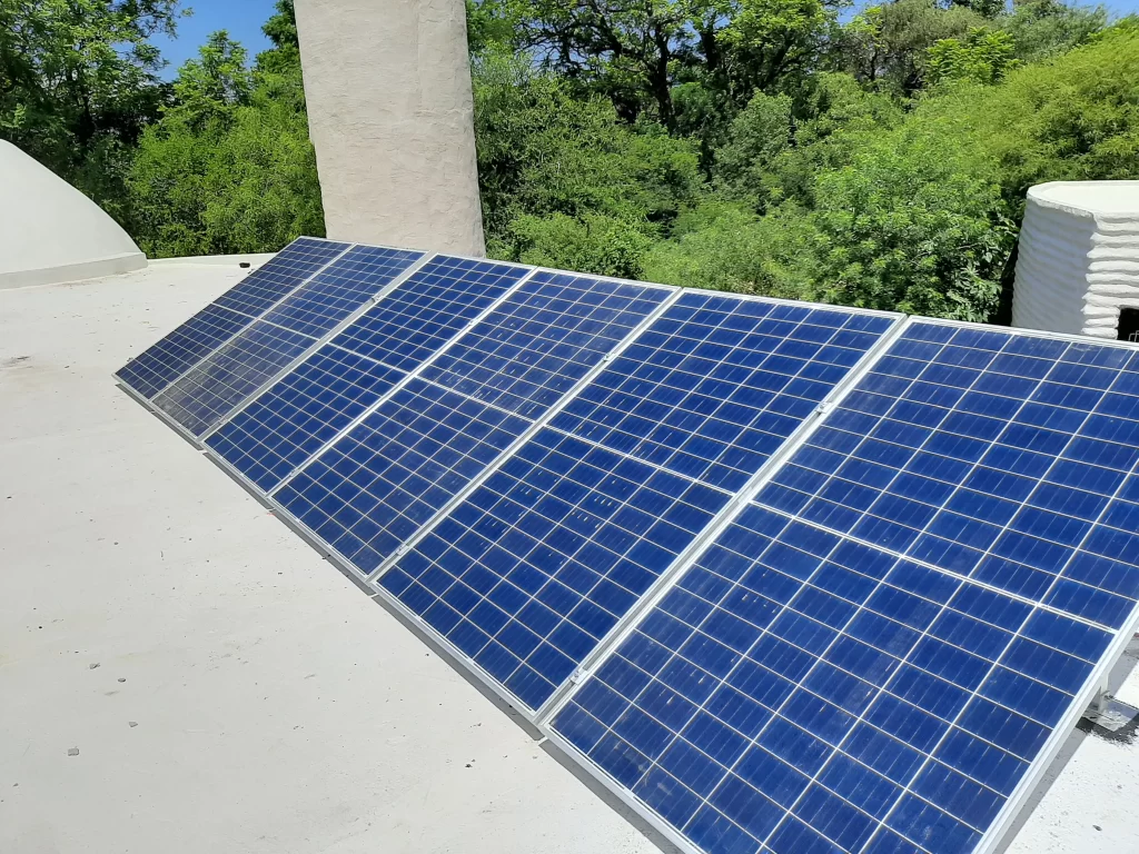 Paneles solares apra generar energía fotovoltaica colocados sobre el techado de una residencia en la ciudad