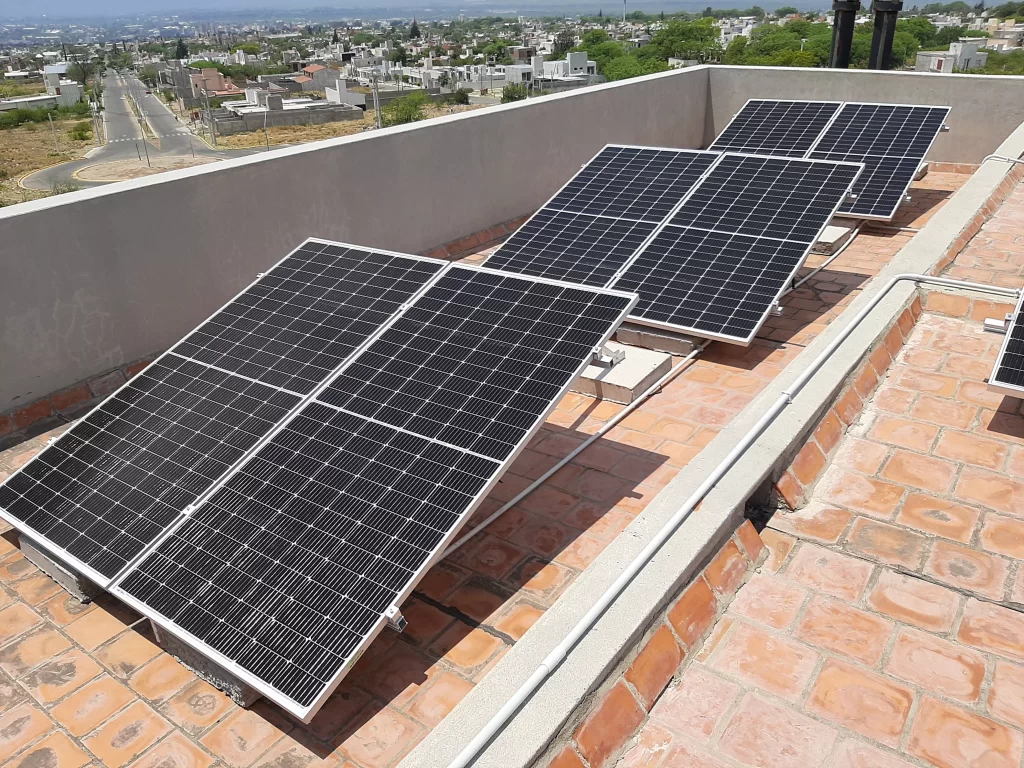 Paneles solares apra generar energía fotovoltaica colocados sobre el techado de una residencia en la ciudad