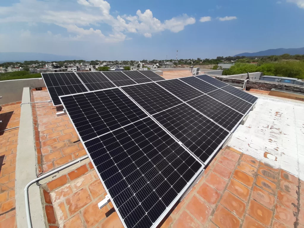 Paneles solares apra generar energía fotovoltaica colocados sobre el techado de una residencia en la ciudad