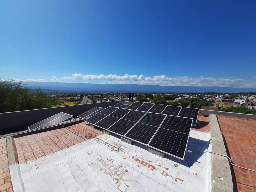 Paneles solares apra generar energía fotovoltaica colocados sobre el techado de una residencia en la ciudad