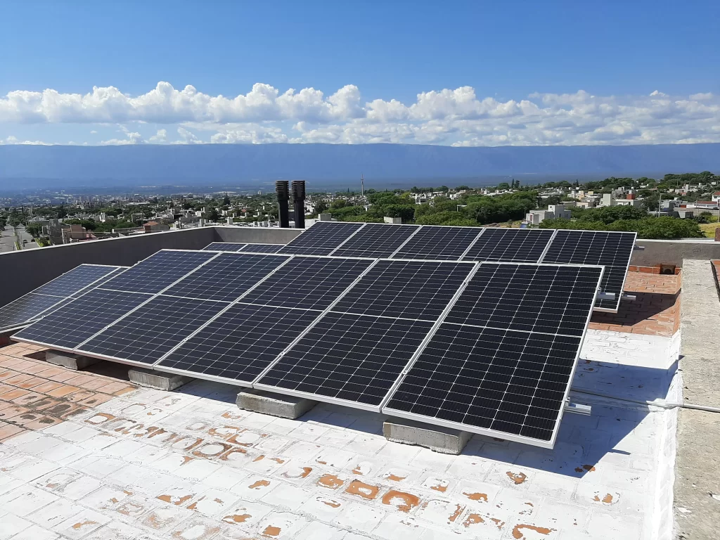 Paneles solares apra generar energía fotovoltaica colocados sobre el techado de una residencia en la ciudad